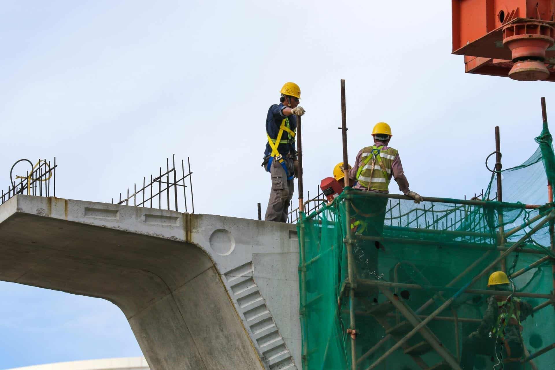 Men in high visibility clothing working on a site for bond management services