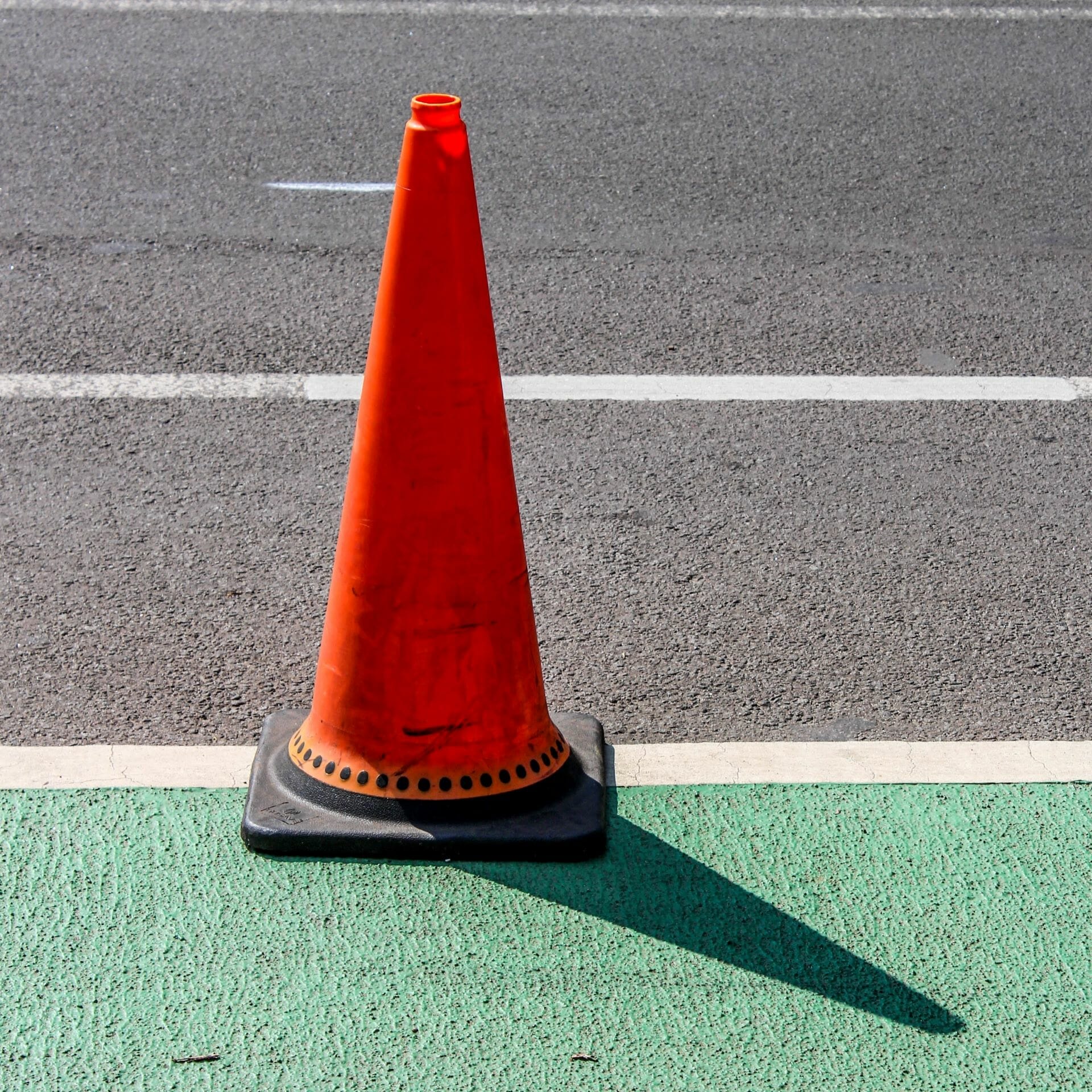 Traffic cone marking the street where a crew is using ground-penetrating radar.