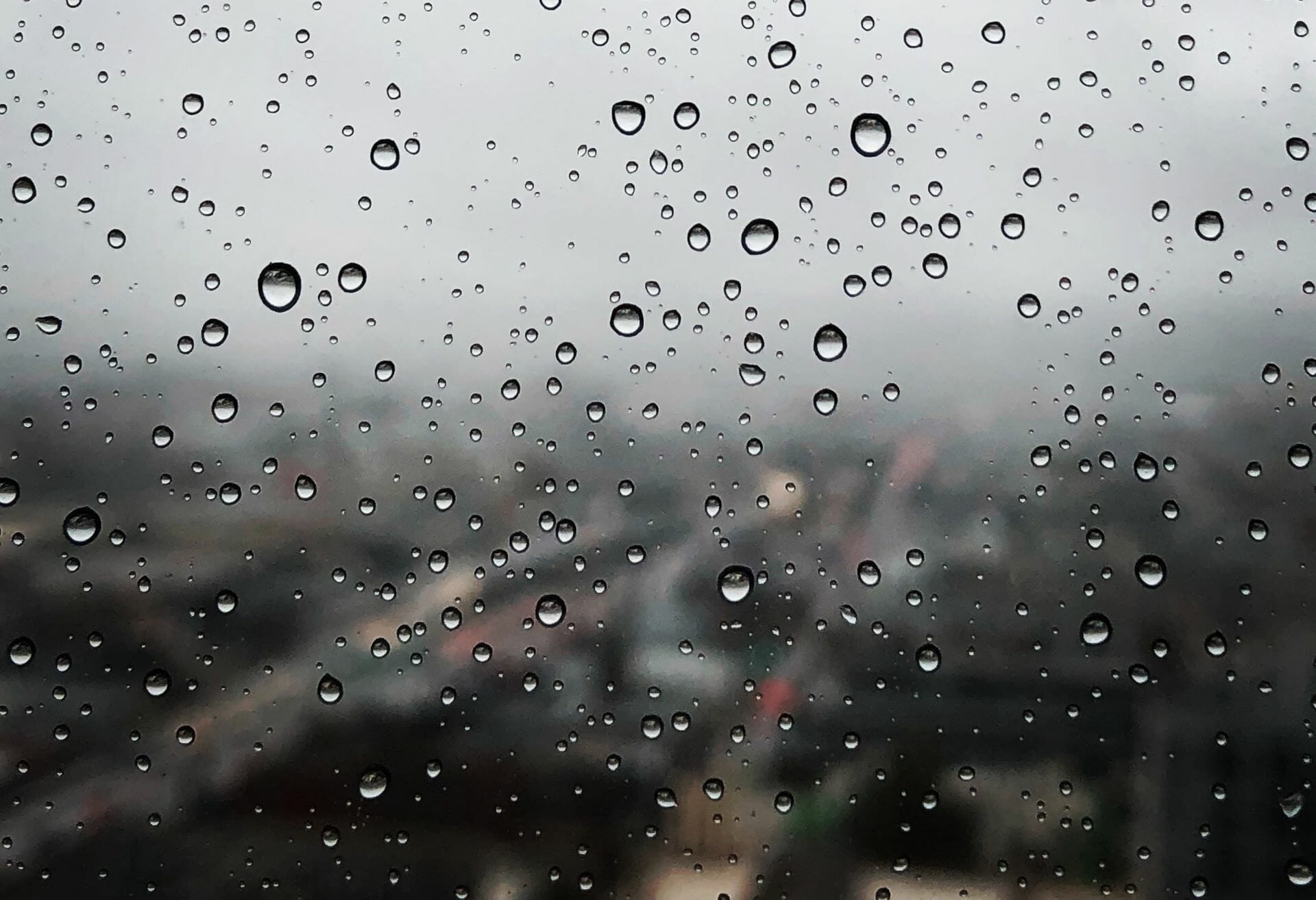 Rain drops from stormwater on a window overlooking the D.C., VA, and MD area during spring time.