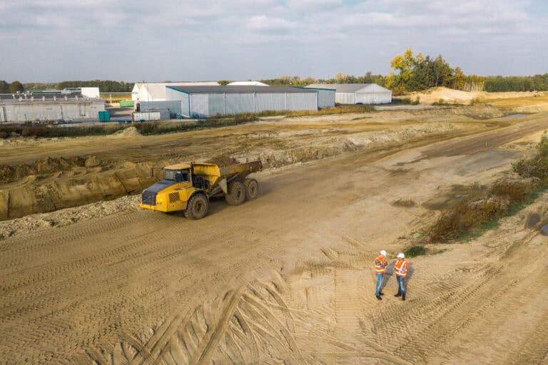 Two workers preparing the construction site for the excavator