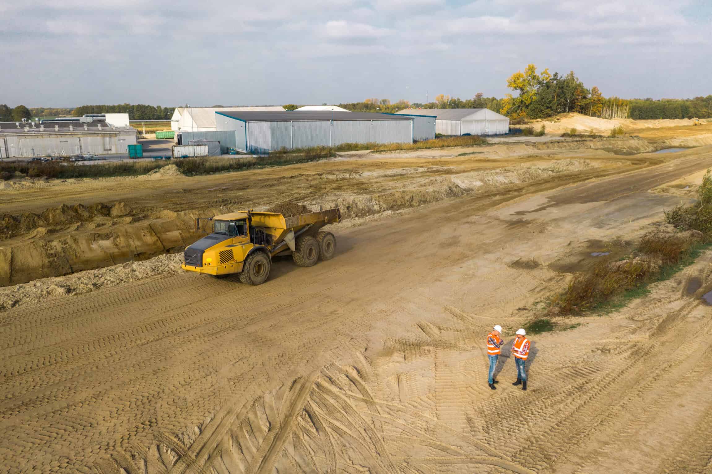 Two workers preparing the construction site for the excavator