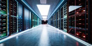 Modern data center server corridor with illuminated server racks and networking equipment on both sides of a high-tech server room.