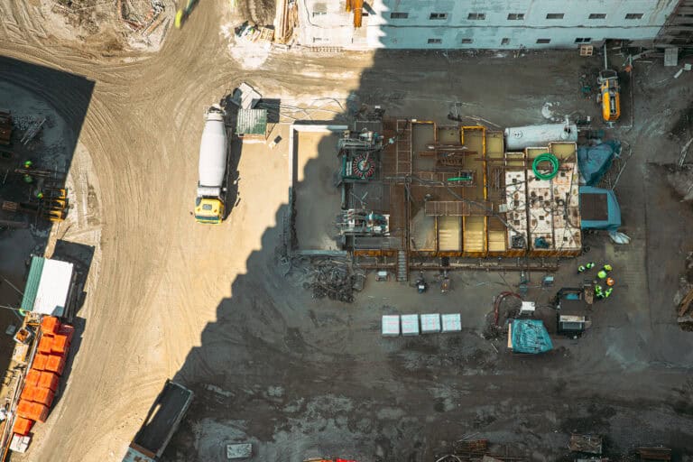 aerial view of active multistory residential construction site with concrete work and equipment